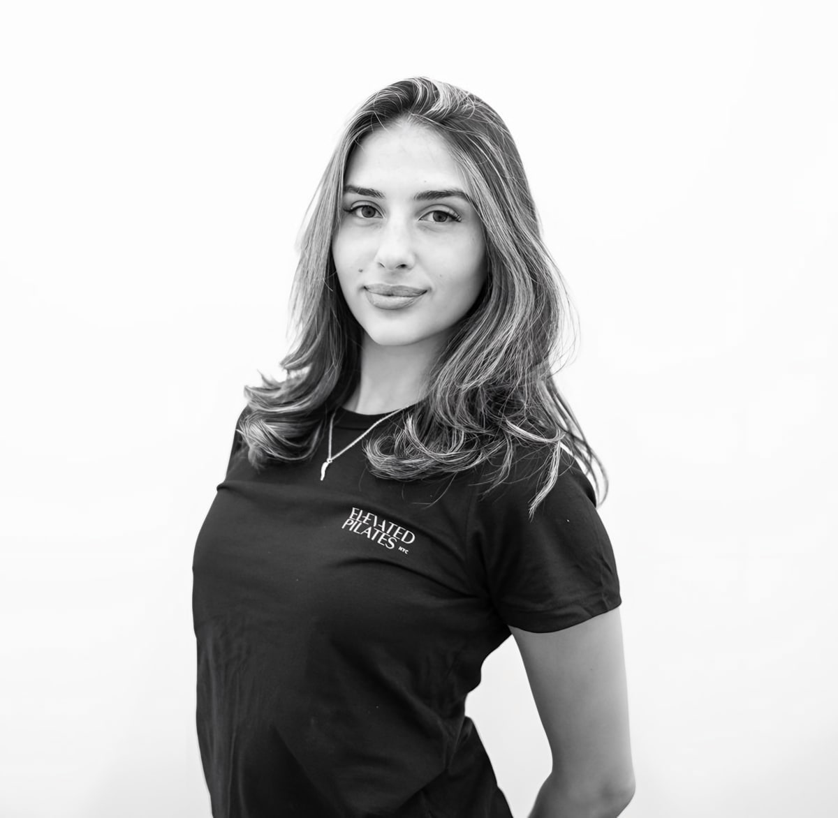 Woman instructor in black Elevated Pilates shirt, black and white portrait